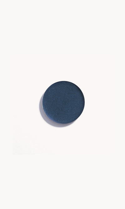 Navy blue cream eye shadow pan on a white background