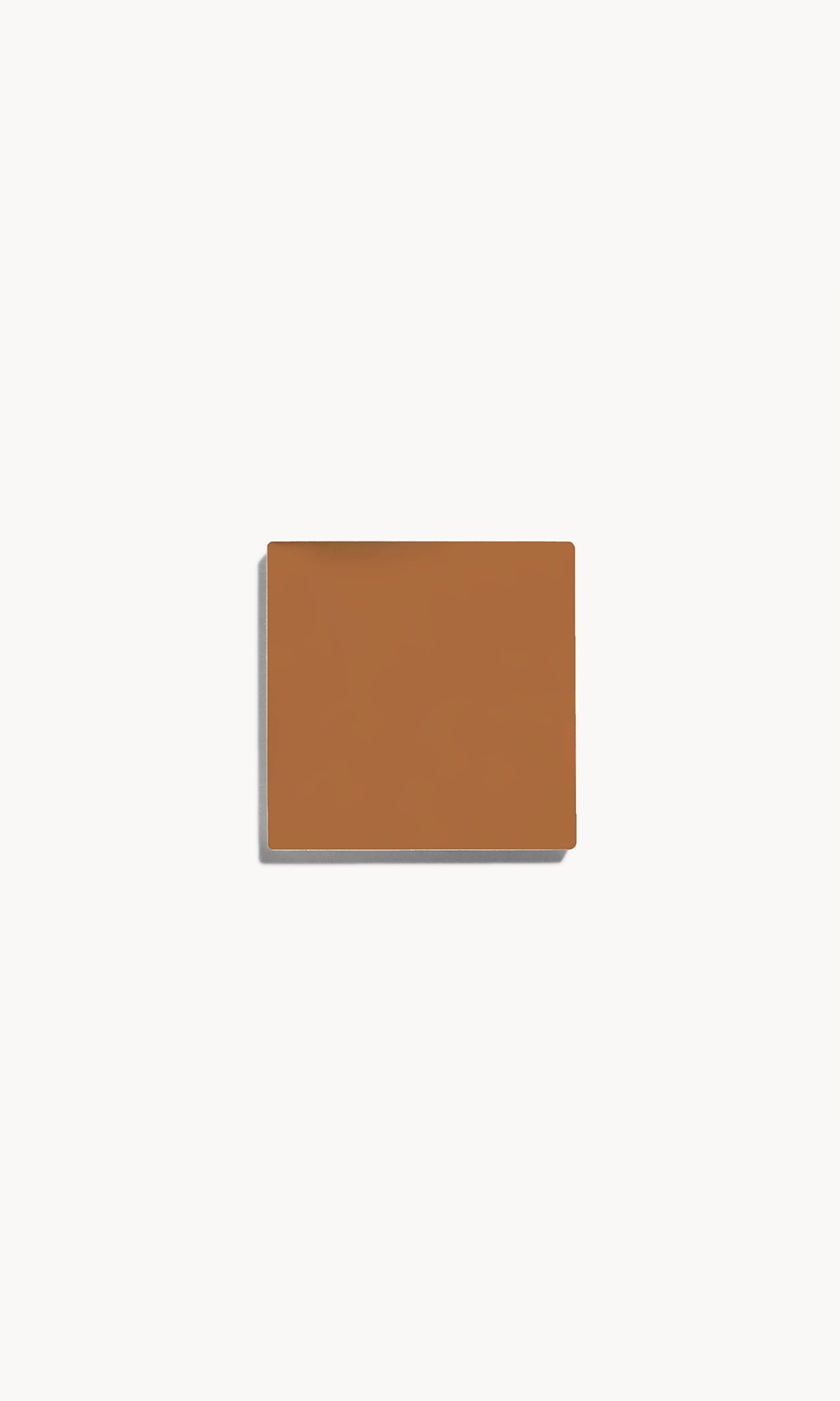 Square of warm tan cream foundation on a white background